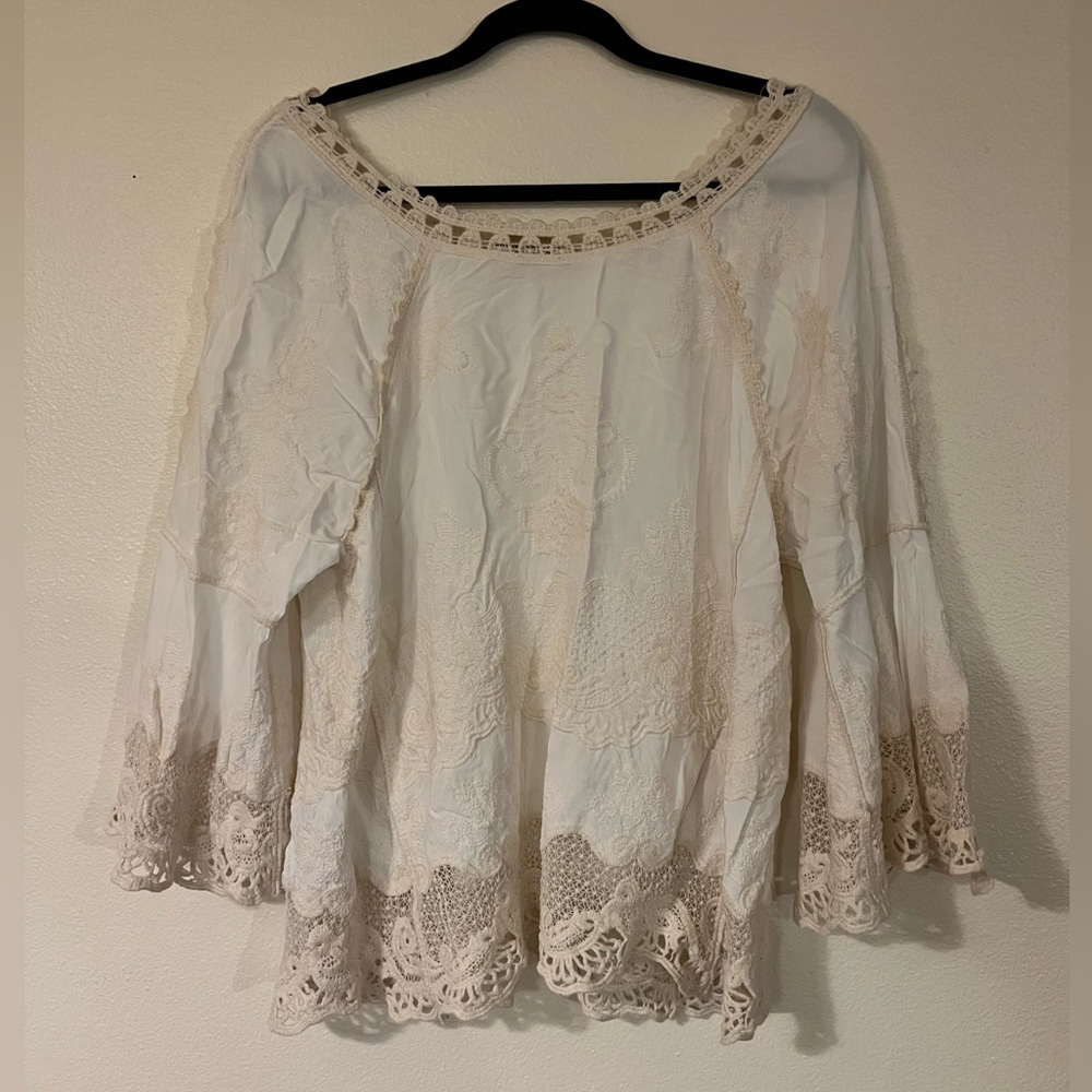 Lace embroidered top, with bell sleeves. Sleeves have side slits. EUC